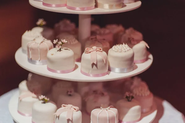 Bella torta nuziale bianca e colorata. Una sposa e uno sposo stanno tagliando la loro torta nuziale — Foto Stock