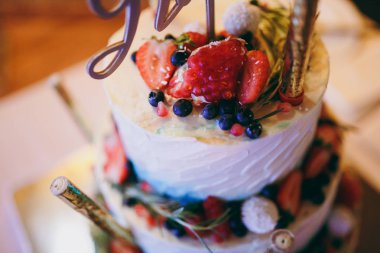 Güzel beyaz ve renkli düğün pastası. Bir gelin ve damat onların düğün pastası kesme