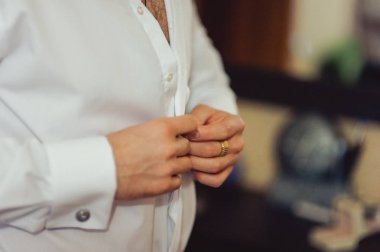 Gömleğinin düğmelerini ilikleyen adam