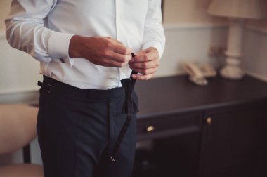 Gömleğinin düğmelerini ilikleyen adam