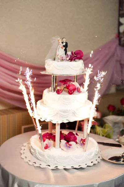 Schöne weiße und farbige Hochzeitstorte. Braut und Bräutigam schneiden ihre Hochzeitstorte an — Stockfoto