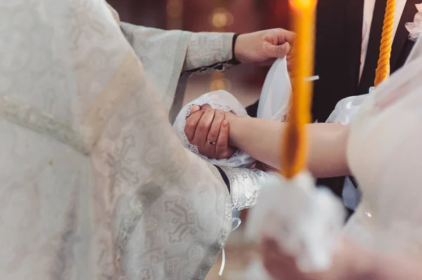 Hände von Braut und Bräutigam banden Hochzeitstücher. Der Priester bindet das Handtuch der Braut. Hände junger Paare in der Kirche. Paar hält bei kirchlicher Zeremonie Händchen in Handtuch. Hochzeitstag. — Stockfoto