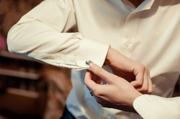 O noivo prende o abotoadouro na manga da camisa close-up — Fotografia de Stock