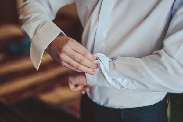 O noivo prende o abotoadouro na manga da camisa close-up — Fotografia de Stock