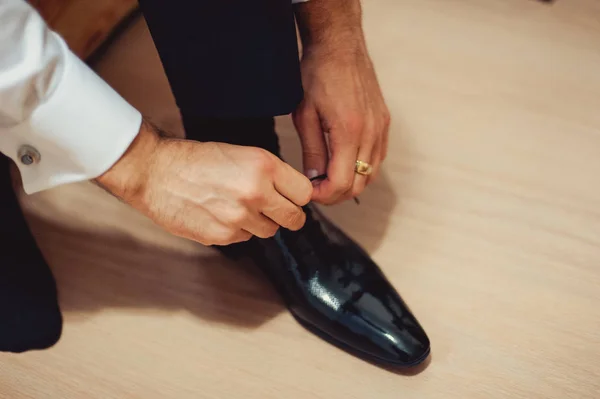 El hombre usa zapatos. Ata los cordones de los zapatos. Estilo masculino. Profesiones. Para prepararse para el trabajo, a la reunión . — Foto de Stock