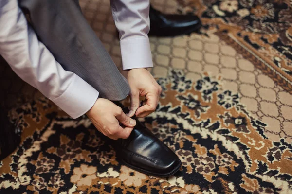 El hombre usa zapatos. Ata los cordones de los zapatos. Estilo masculino. Profesiones. Para prepararse para el trabajo, a la reunión . — Foto de Stock