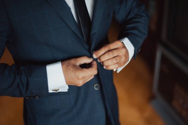 Zarif Damat Düğün ceketli beyaz gömlek ve turkuaz kravat takıyor. Mavi takım damadın elleri.