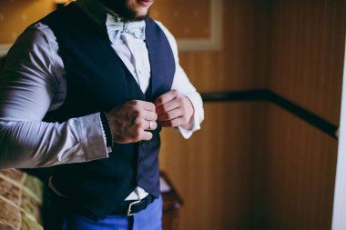 Zarif Damat Düğün ceketli beyaz gömlek ve turkuaz kravat takıyor. Mavi takım damadın elleri.