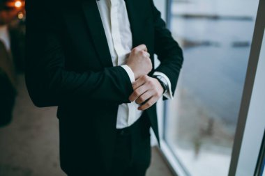 Zarif Damat Düğün ceketli beyaz gömlek ve turkuaz kravat takıyor. Mavi takım damadın elleri.