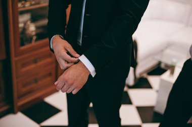 Zarif Damat Düğün ceketli beyaz gömlek ve turkuaz kravat takıyor. Mavi takım damadın elleri.