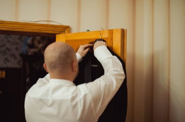 Zarif Damat Düğün ceketli beyaz gömlek ve turkuaz kravat takıyor. Mavi takım damadın elleri.