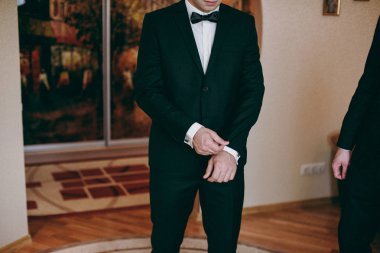 Zarif Damat Düğün ceketli beyaz gömlek ve turkuaz kravat takıyor. Mavi takım damadın elleri.