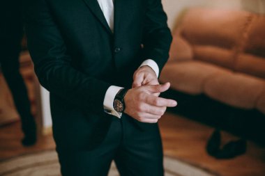 Zarif Damat Düğün ceketli beyaz gömlek ve turkuaz kravat takıyor. Mavi takım damadın elleri.