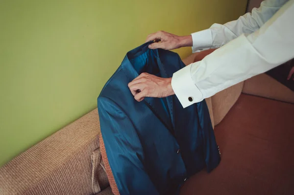 Elegante bruidegom in bruiloft jas wit overhemd en turquoise stropdas dragen. Bruidegom handen op blauwe pak. — Stockfoto