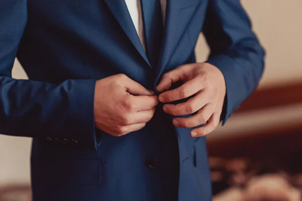 Elegant groom in wedding jacket wearing white shirt and turquoise tie. Groom's hands on blue suit. — Stock Photo, Image