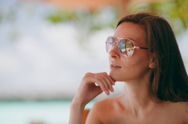 Sahilde oturan güzel gülümseyen kız