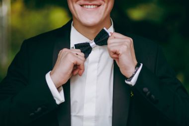 Damat Düğün kostüm ile kelebek adam. Eller, bakım, düzeltmek ayarlamak için moda için. Tonlama Instagram renkleri