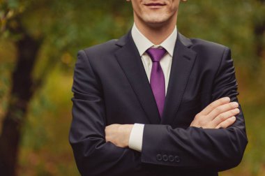 Damat takım elbiseli bir kravat düzeltir. Damat aksesuarları