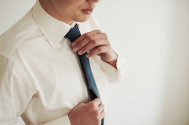 Damat takım elbiseli bir kravat düzeltir. Damat aksesuarları