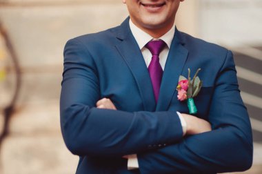 Damat takım elbiseli bir kravat düzeltir. Damat aksesuarları