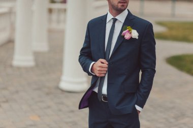 Damat takım elbiseli bir kravat düzeltir. Damat aksesuarları