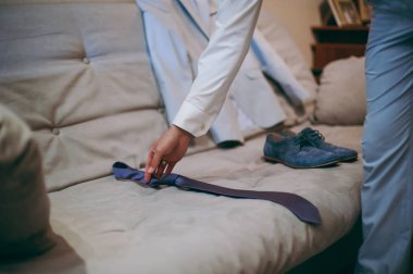 Damat takım elbiseli bir kravat düzeltir. Damat aksesuarları