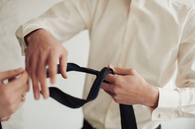 Damat takım elbiseli bir kravat düzeltir. Damat aksesuarları