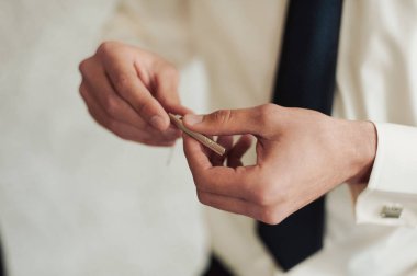 Damat takım elbiseli bir kravat düzeltir. Damat aksesuarları