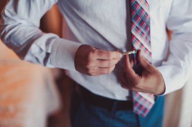 Damat takım elbiseli bir kravat düzeltir. Damat aksesuarları