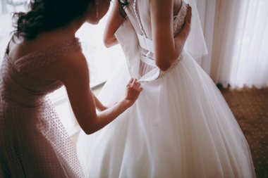 Moda nedime elbiseler yardım aşınma yay üzerinde düğün elbise gelin arkasında. Sabah düğün günü.