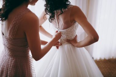 Moda nedime elbiseler yardım aşınma yay üzerinde düğün elbise gelin arkasında. Sabah düğün günü.