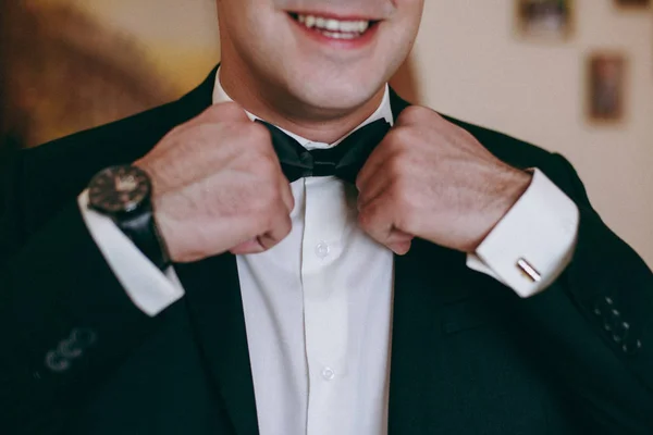 Мужчина жених в свадебном костюме с бабочкой. Руки, забота, исправление, настройка, мода. Тонизация цветов в Instagram — стоковое фото