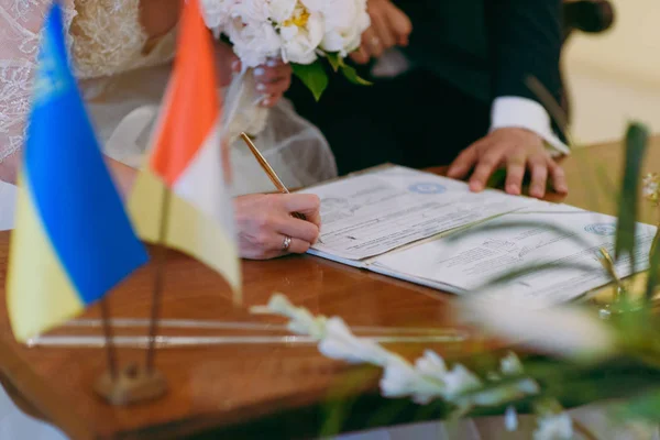 Cerimonia della firma. Gli sposi firmano i documenti sul matrimonio — Foto Stock