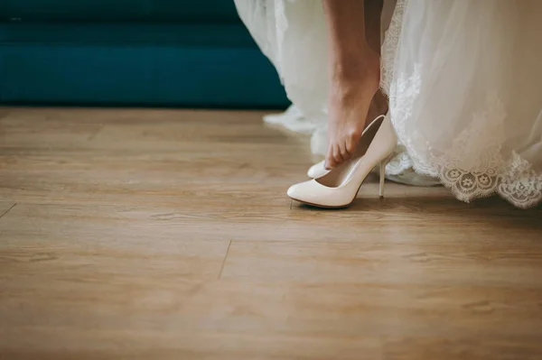 Braut zieht Hochzeitsschuhe an — Stockfoto