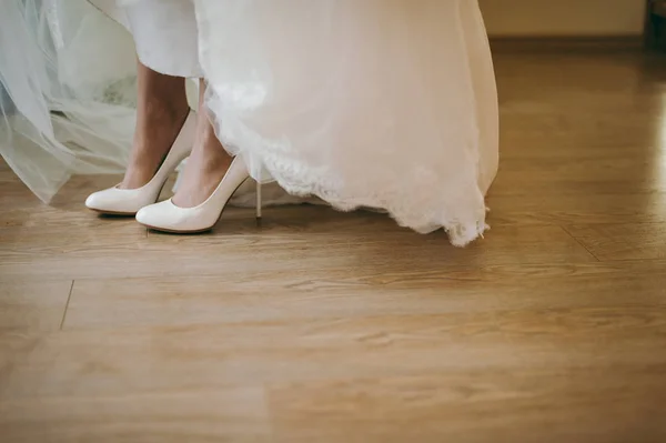 Braut zieht Hochzeitsschuhe an — Stockfoto