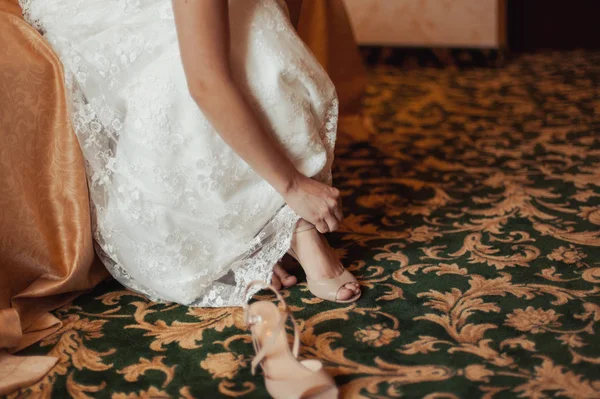 Noiva colocando sapatos de casamento — Fotografia de Stock