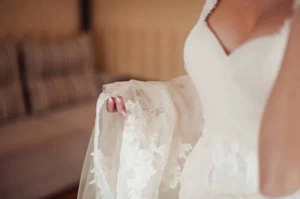Módní družičky šaty pomáhal nosit luk na zadní svatební šaty nevěsty. Svatební den ráno. — Stock fotografie