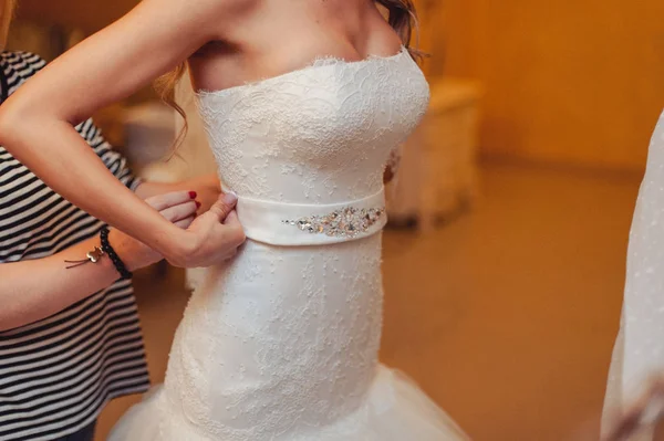 Los vestidos de dama de honor de moda ayudaron a usar lazo en la parte posterior de la novia vestido de novia. Día de la boda mañana . — Foto de Stock