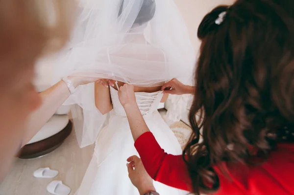 Moda nedime elbiseler yardım aşınma yay üzerinde düğün elbise gelin arkasında. Sabah düğün günü. — Stok fotoğraf