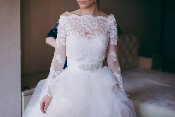 Gaun pengantin wanita yang modis membantu memakai busur di belakang pengantin wanita. Pagi hari pernikahan . — Stok Foto