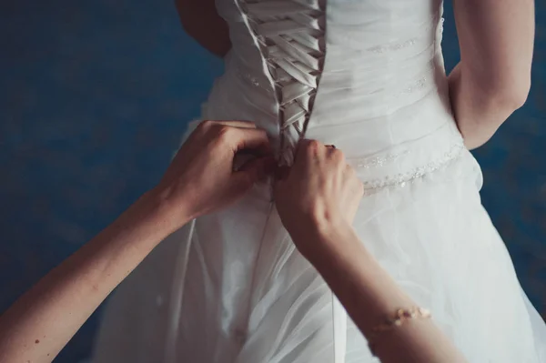 Moda nedime elbiseler yardım aşınma yay üzerinde düğün elbise gelin arkasında. Sabah düğün günü. — Stok fotoğraf