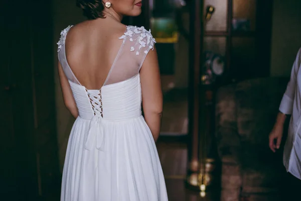 Vestidos de damas de honra na moda ajudou a usar o arco na parte de trás da noiva vestido de noiva. Dia do casamento da manhã . — Fotografia de Stock