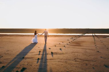 Kum bir yürüyüş gelin ve damat deniz alanı günbatımı mimari düğün çift çimen