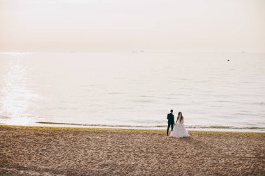 Kum bir yürüyüş gelin ve damat deniz alanı günbatımı mimari düğün çift çimen