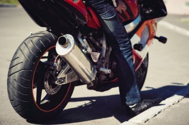 Bir adam bir motosiklet üzerinde kenarda duruyor