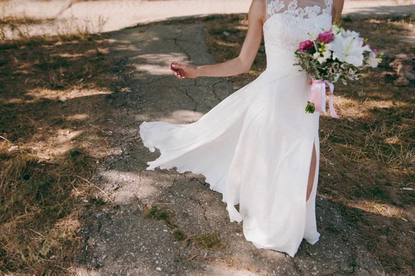 Boda pareja en un paseo novia y novio mar campo puesta del sol arquitectura hierba arena — Foto de Stock