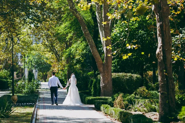 Bröllopsparet på en promenad bruden och brudgummen havet solnedgång arkitekturområdet gräs sand — Stockfoto