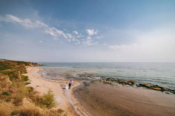 Kum bir yürüyüş gelin ve damat deniz alanı günbatımı mimari düğün çift çimen