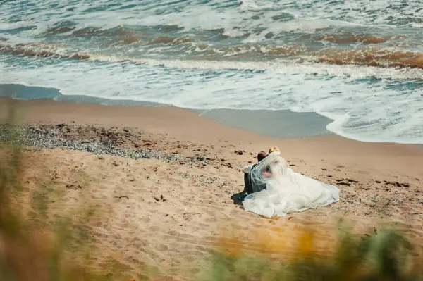 Casamento casal em um passeio noiva e noivo mar campo pôr do sol arquitetura grama areia — Fotografia de Stock