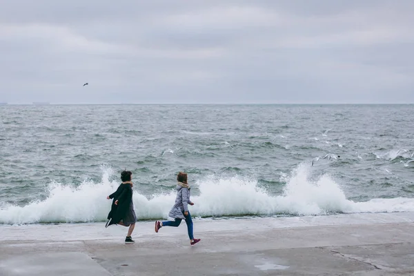 Happy, young couple is running on the beach in spring — Stock Photo, Image